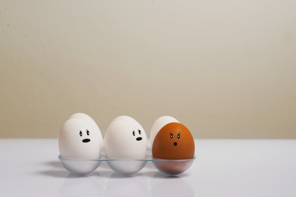3 white eggs and 1 brown egg with expressions